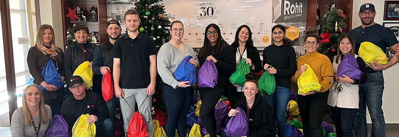 Colourful backpacks for homeless and people holding them