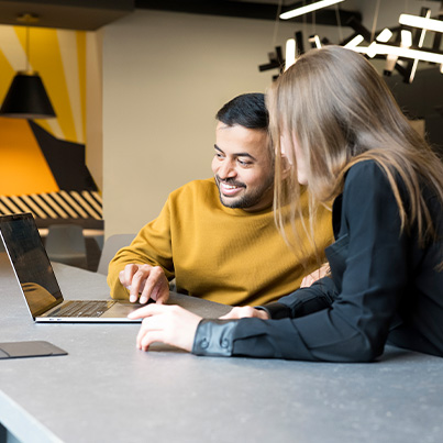 2 people working on a laptop