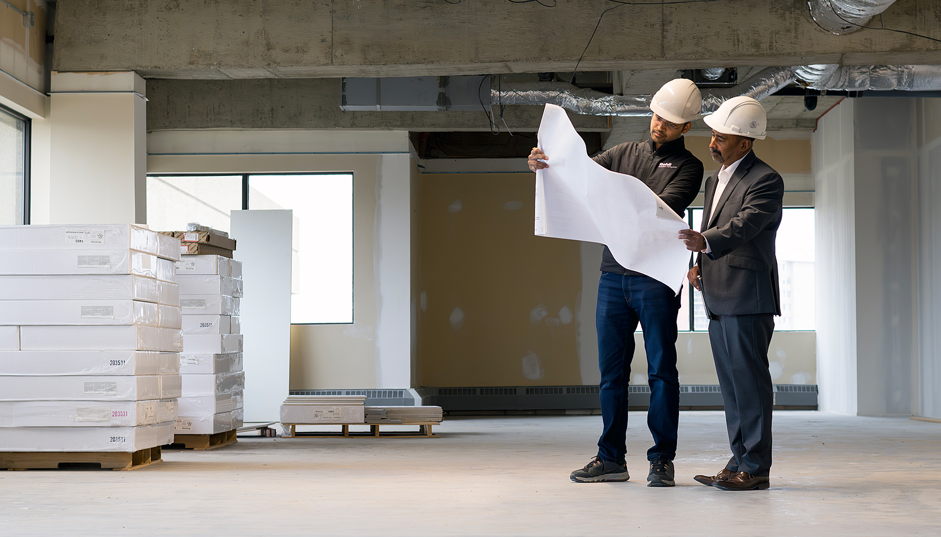 Two workers looking at a plan.